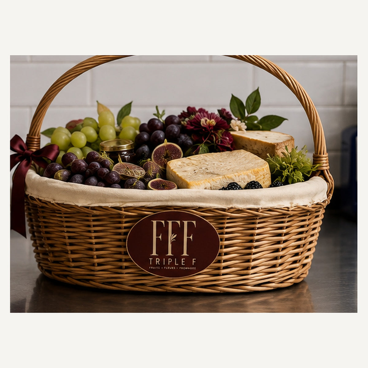 La Table — grand panier en osier Triple F garni de raisins, figues, mûres, fromages affinés et fleurs